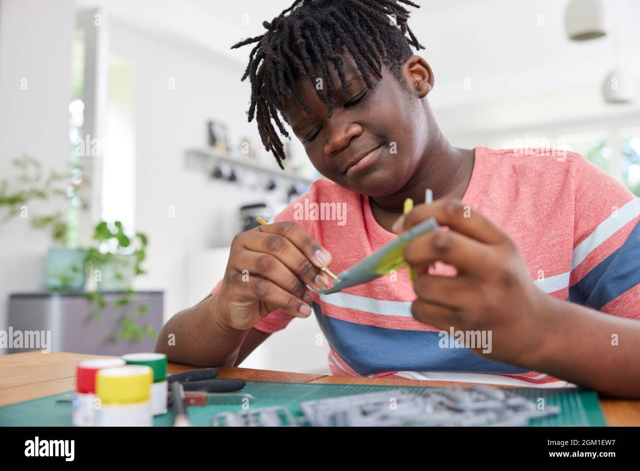 Teenage Boy Model Aeroplane From Kit On Table At Home Stock Photo