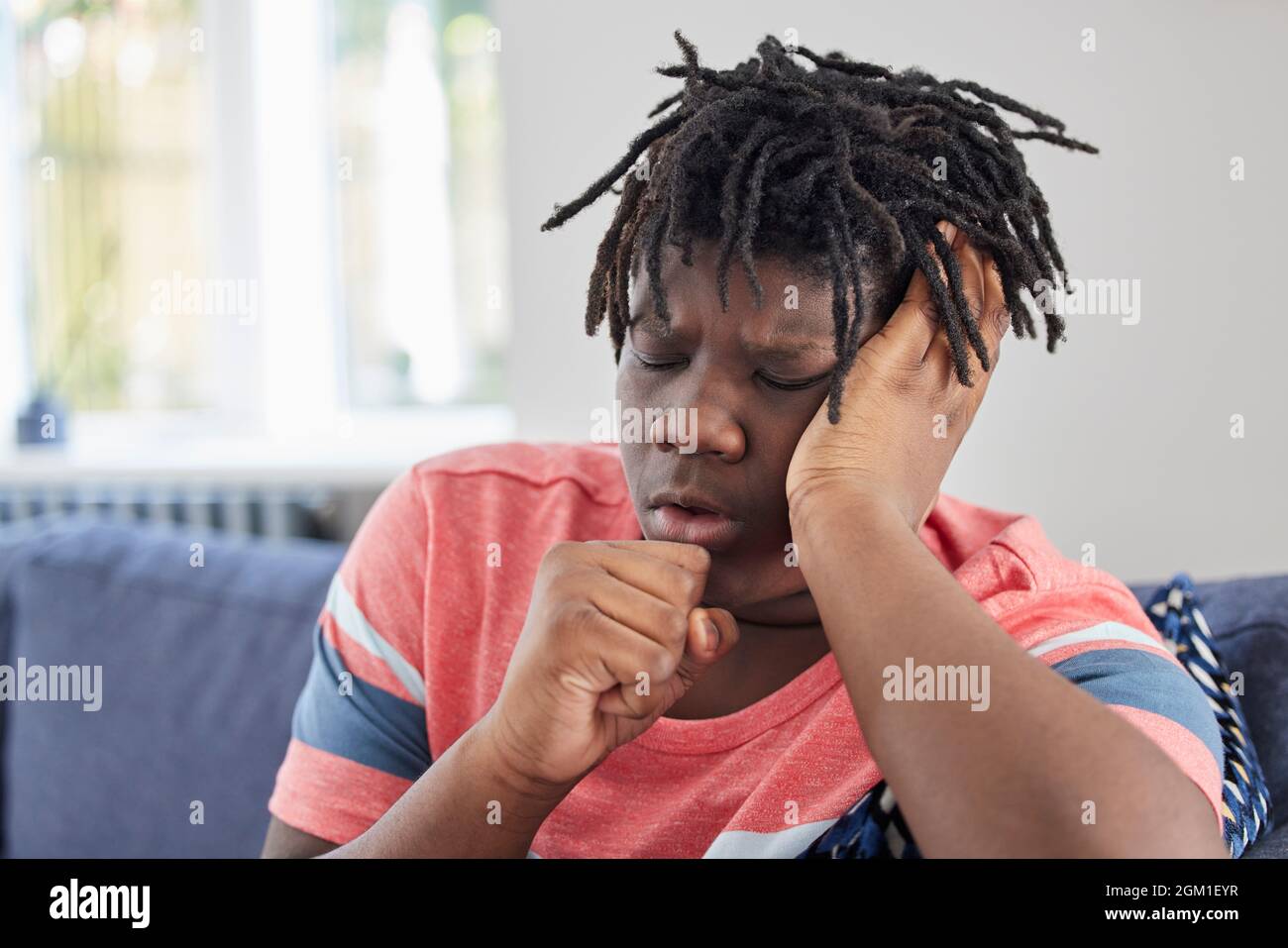 Teenage Boy Suffering With Cough At Home Stock Photo