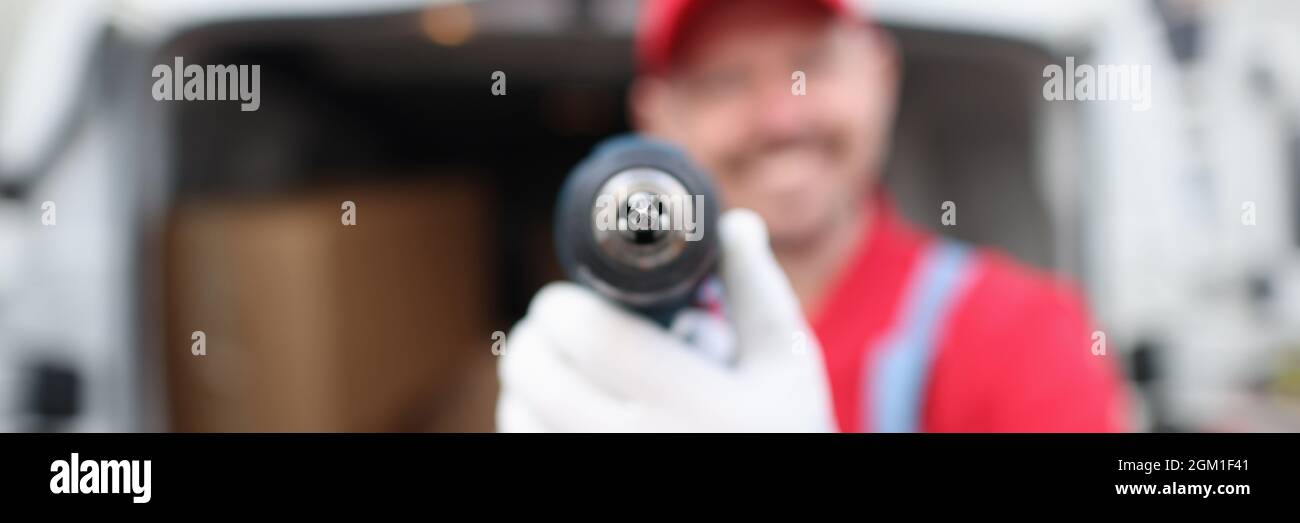 Smiling male master builder holding drill closeup Stock Photo