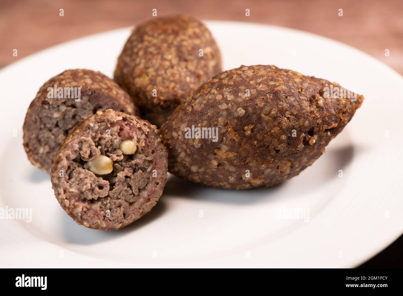 Traditional kebbe and pita bread on big round plate in lebanese restaurant Stock Photo