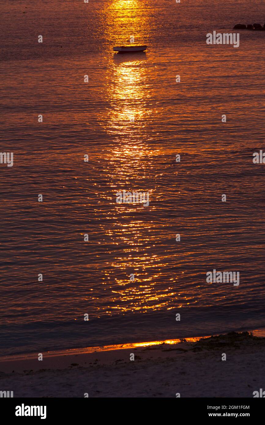 Reddish sunset on the calm and calm sea with fishing boats in backlight ...