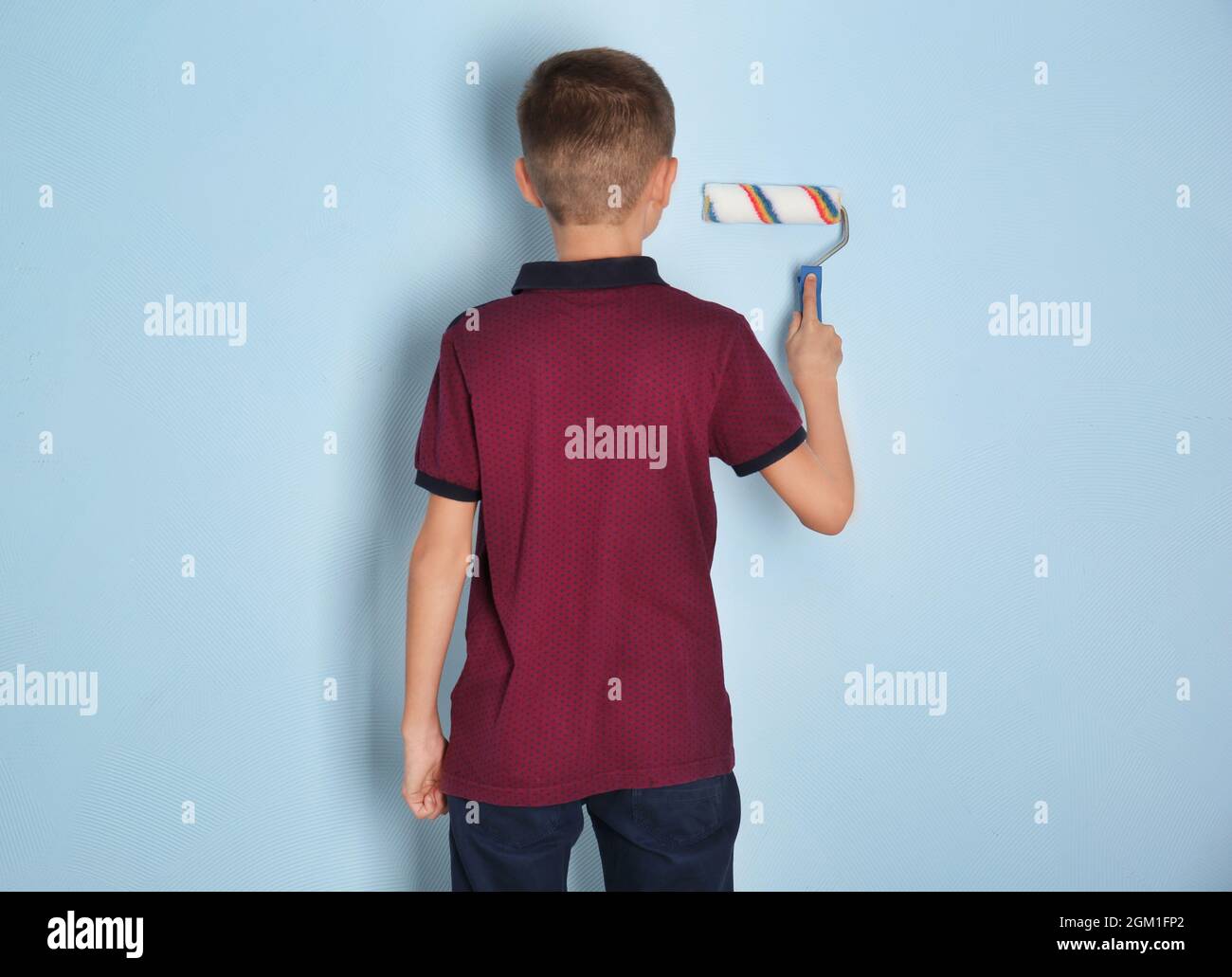 Cute little boy painting wall with roller Stock Photo Alamy