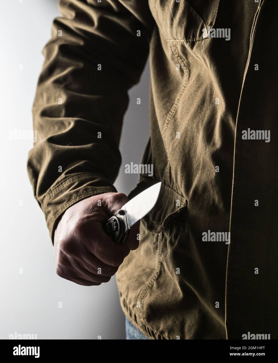 Man holding a knife in a threatening stance ready to fight Stock Photo ...