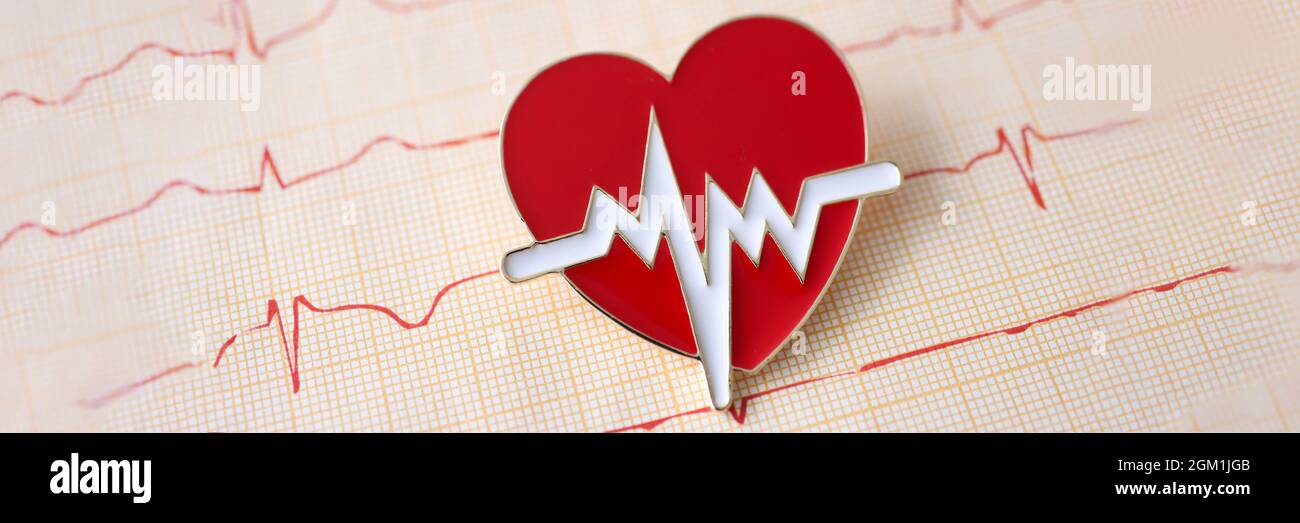Result of electrocardiogram with icon lies on table Stock Photo