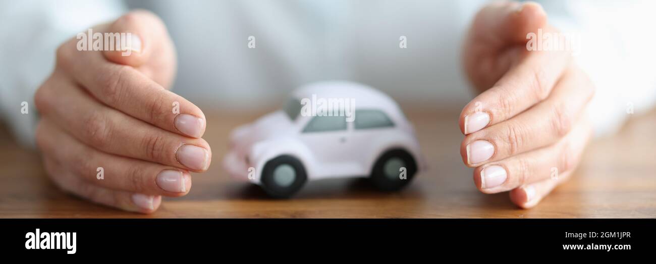 There is white car inside woman hands Stock Photo