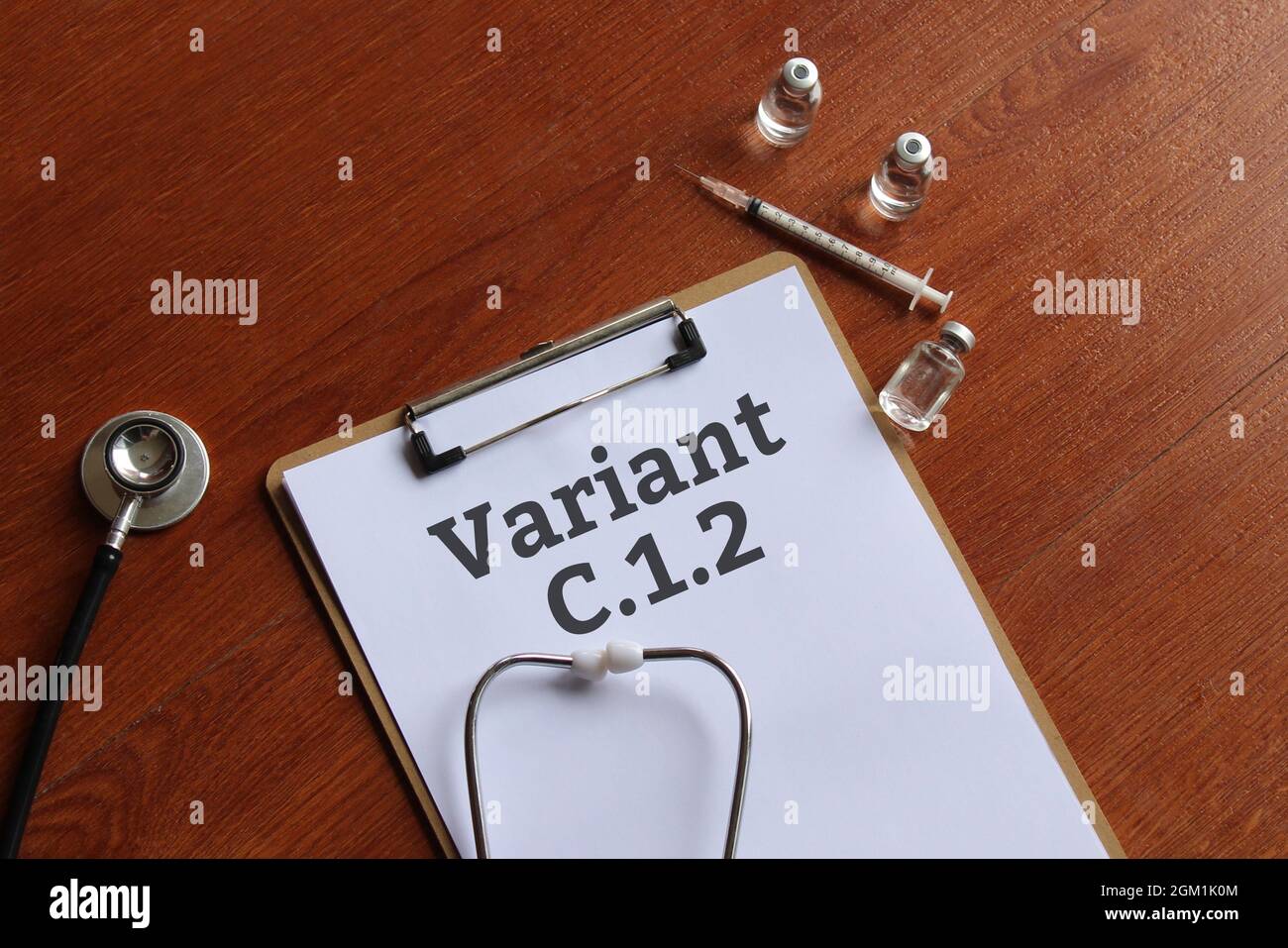 Medical concept. Top view of paper clipboard with text Covid-19 variant C.1.2, stethoscope, glass vial and syringe. Stock Photo