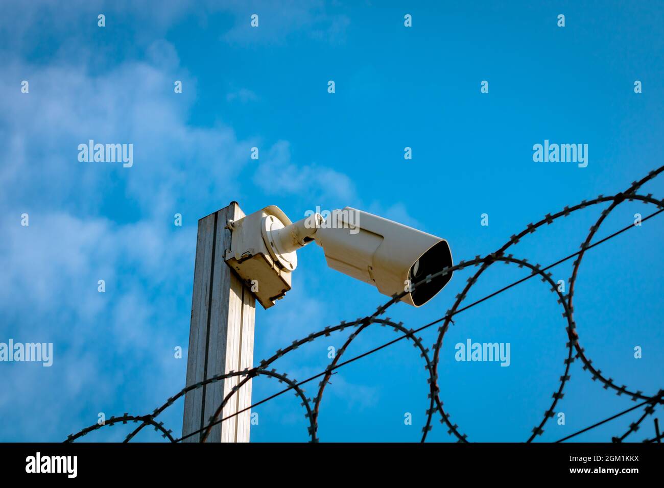 A security camera or CCTV camera with barbed wire fence. Security