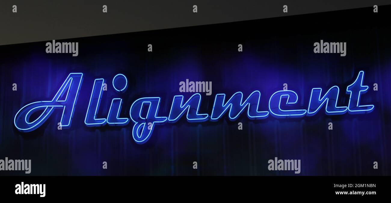Blue Neon Alignment Sign on Metal Building at Night Stock Photo - Alamy