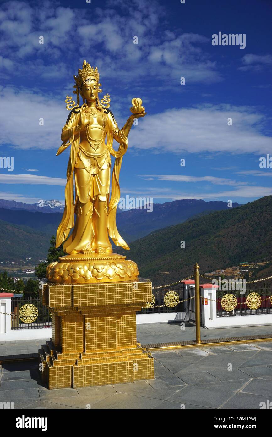 A graceful golden goddess statue stands on the upper terrace around the Buddha Dordenma statue in the Kuensel Phodrang nature park near Thimphu Bhutan Stock Photo