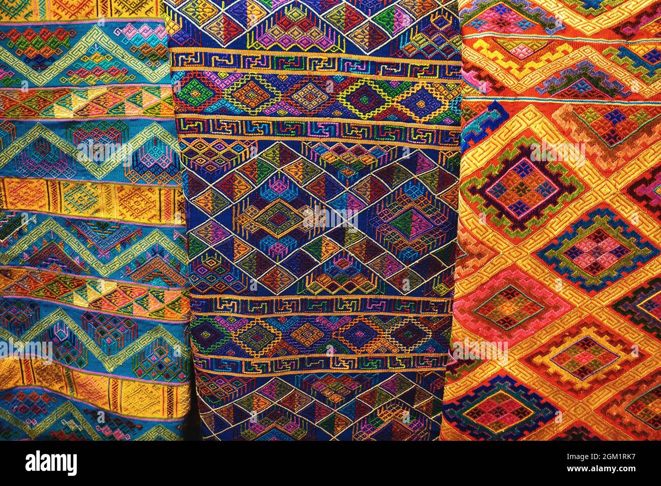 Colorful assortment of beautiful Bhutanese textiles with traditional intricate handwoven and embroidered patterns on display in Thimphu, Bhutan. Stock Photo