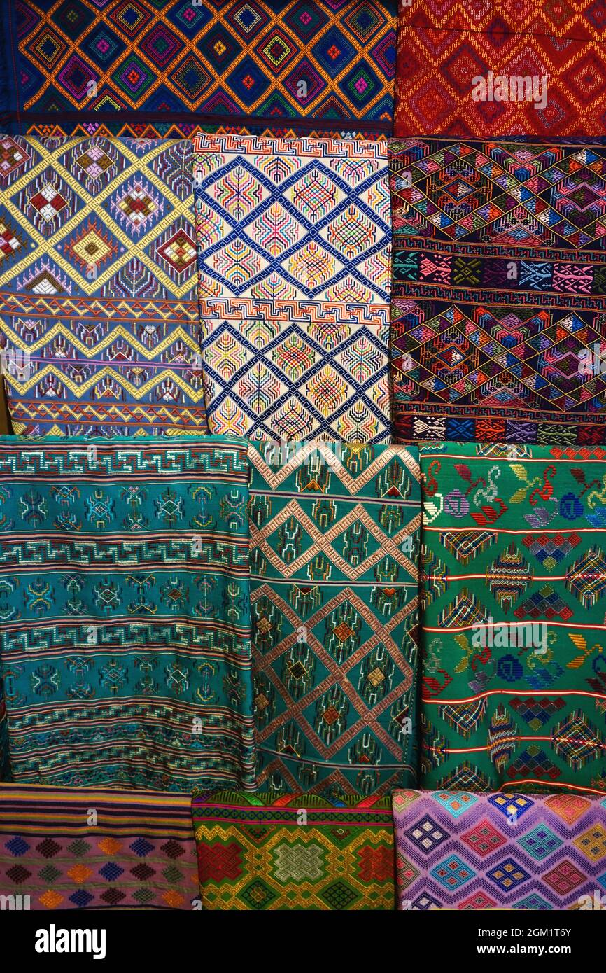 A variety of beautiful Bhutanese handmade fabrics and textiles in greens and darker colors with traditional patterns on display in Thimphu, Bhutan Stock Photo