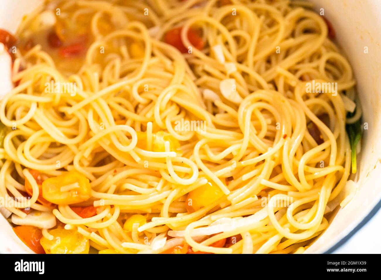 Preparing one pot pasta in enameled cast iron dutch oven Stock Photo