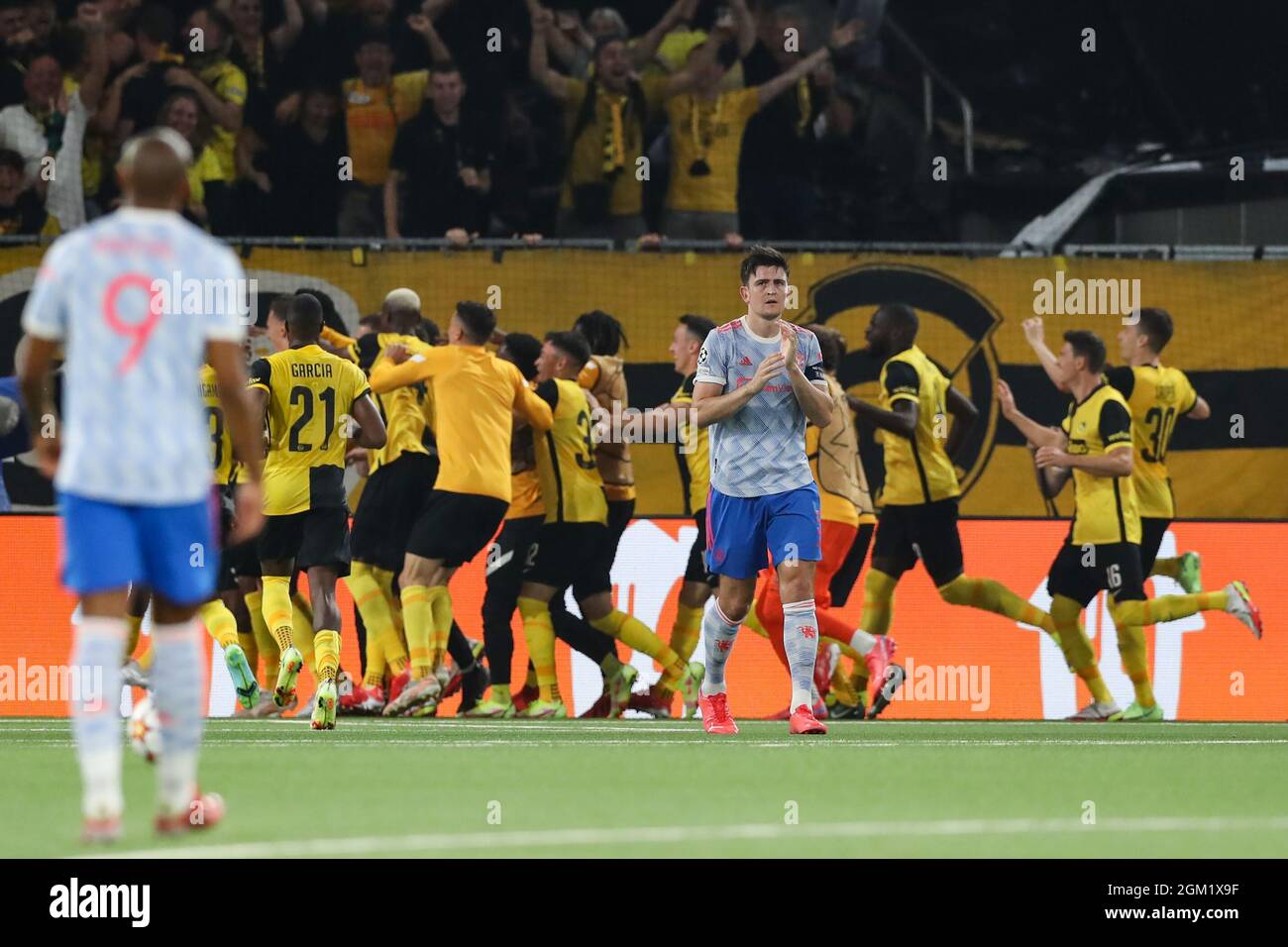 Berne, Switzerland, 14th September 2021. Harry Maguire of Manchester United  reacts as Young Boys' players celebrate in the background following Jordan  Siebatcheu's late winner during the UEFA Champions League match at Stadion