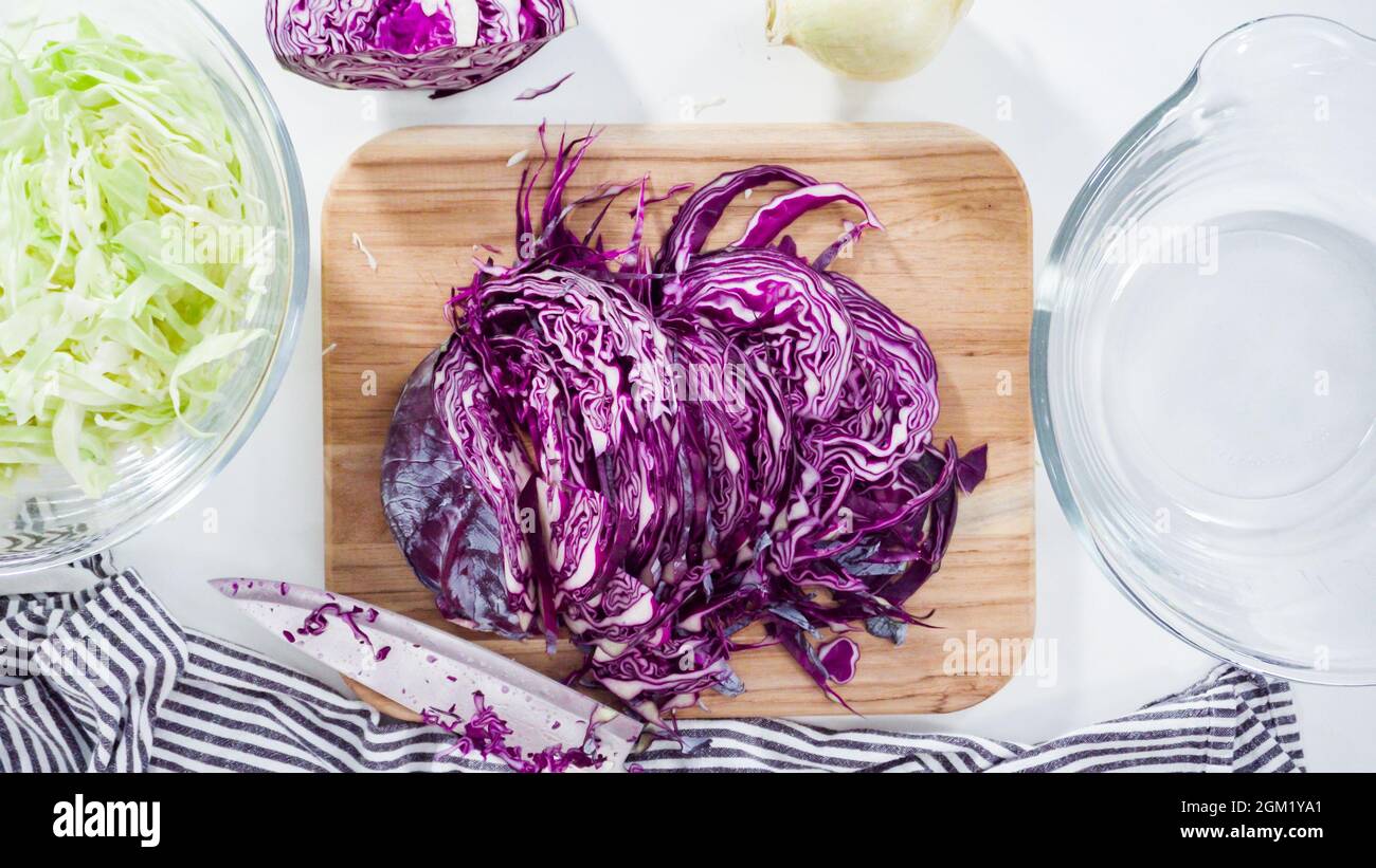 Flat lay. Step by step. Shredding organic cabbage on a wood cutting