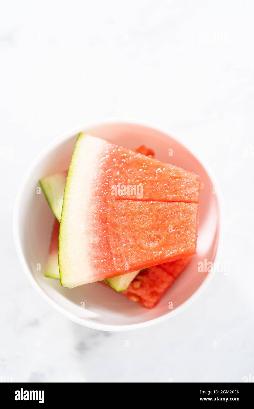 Cutting riped red watermelon to prepare frozen watermelon margarita ...
