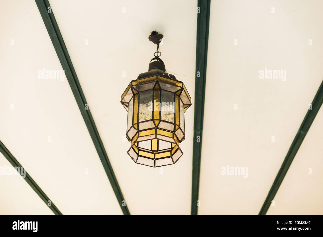 decorative lamp in the shape of a lantern hanging from the ceiling to illuminate the room Stock Photo