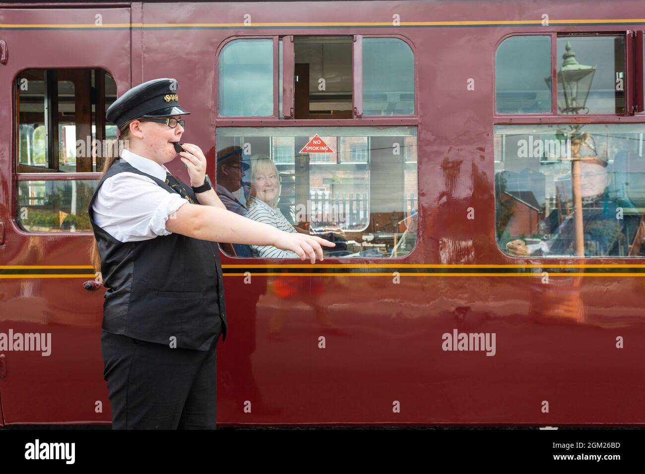 Kidderminster, Worcs, UK. 16th Sep, 2021. Volunteer steam train dispatcher Kaylie Armishaw blows her whistle as a steam train embarks on a day's travel on the opening day of the Severn Valley Railway's Autumn Steam Gala, Kidderminster, Worcestershire. The gala lasts until Sunday 19th September and features guest locos. Credit: Peter Lopeman/Alamy Live News Stock Photo