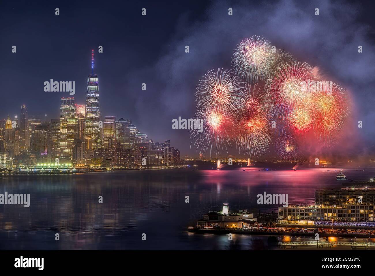 WTC NYC Fireworks - Jersey City, New Jersey fireworks by the New York City skyline with One World Trade Center and other buildings in lower Manhattan. Stock Photo