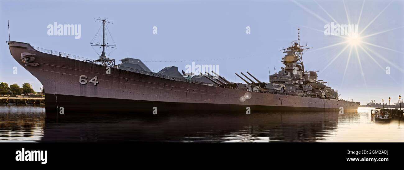 USS Wisconsin BB-64 Pano - Panoramic view of the setting sun by the USS Wisconsin which is an Iowa-class battleship at Norfolk, Virginia.  This image Stock Photo