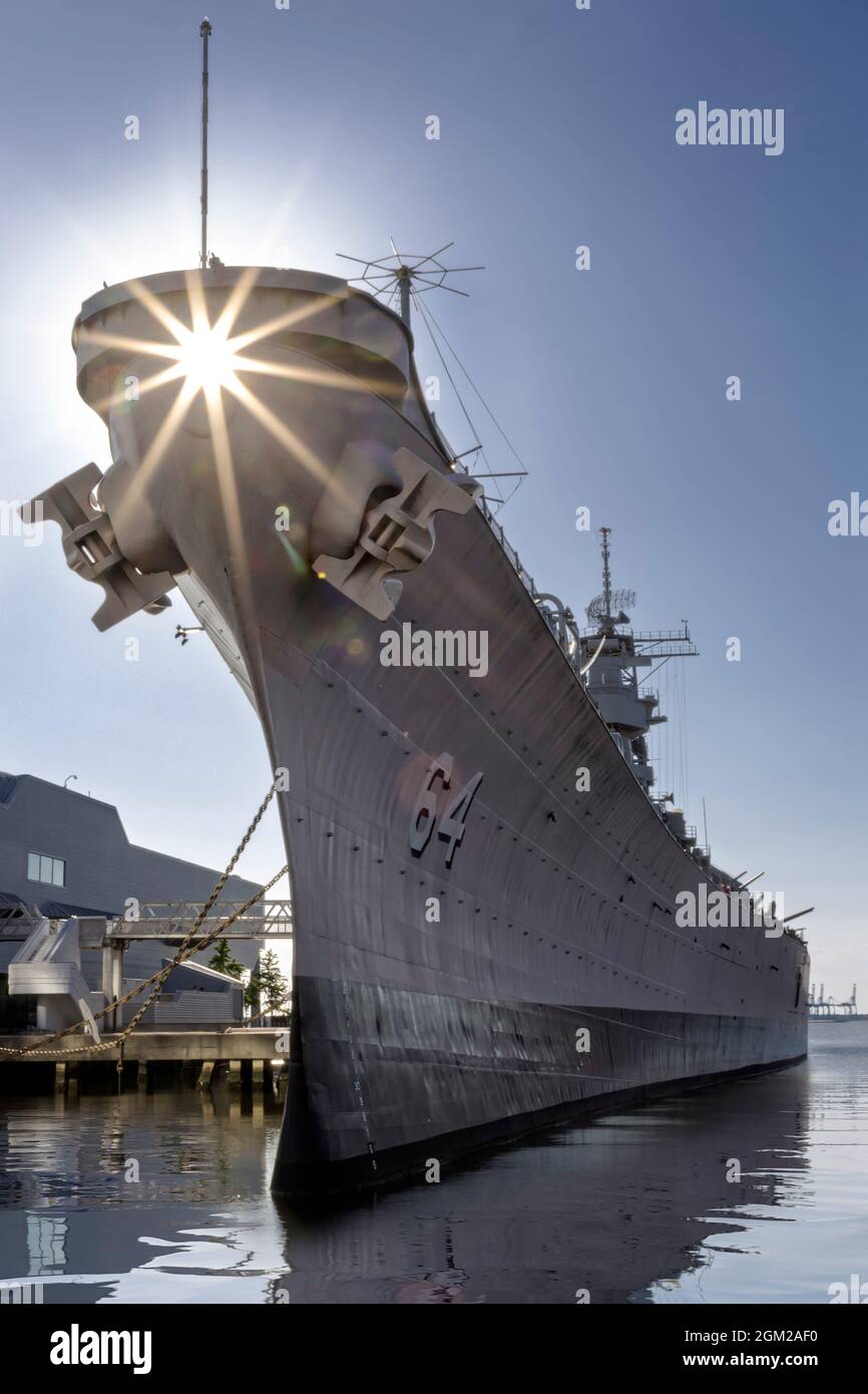 USS Wisconsin BB-64 Norfolk, VA - Upper view of the setting sun behind the USS Wisconsin which is an Iowa-class battleship at Norfolk, Virginia.  This Stock Photo