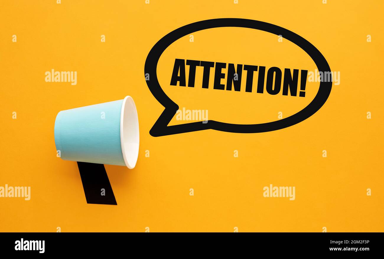 Paper cup used as a megaphone with attention message in a speech bubble ...