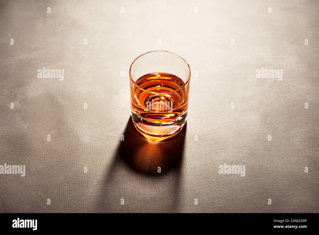Glass of elegant straight or neat whiskey on a bar counter with dark