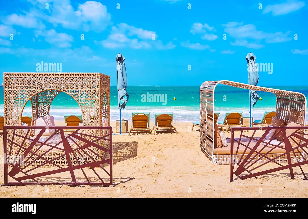 The wooden sunbeds and scenic beach pavilions with trestle beds and