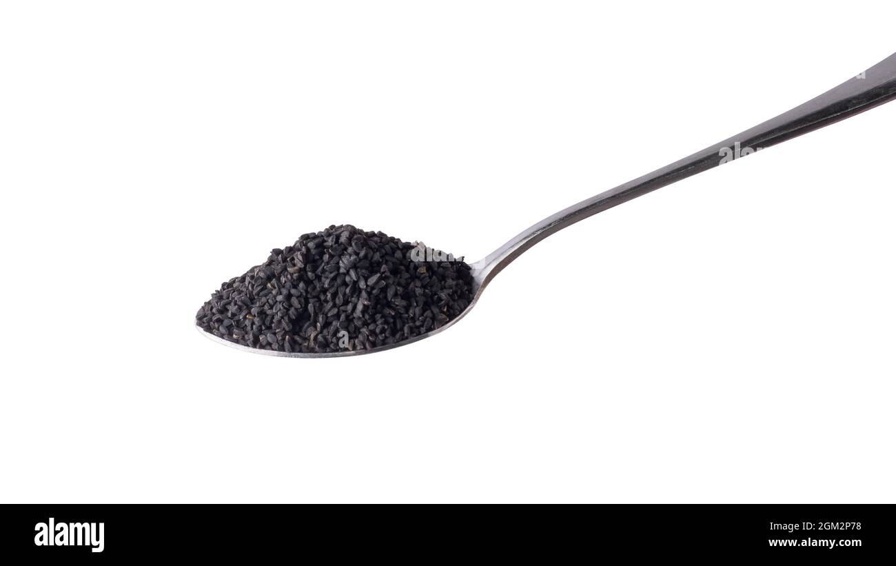 black seeds, also known as black cumin or caraway or kalonji, on a spoon isolated on white background Stock Photo
