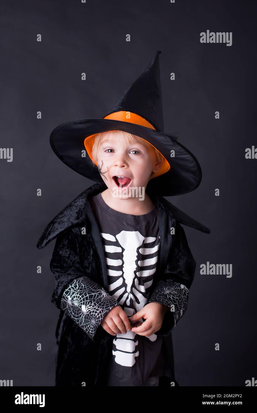 Child, dressed for Halloween, playing at home, isolated image on black