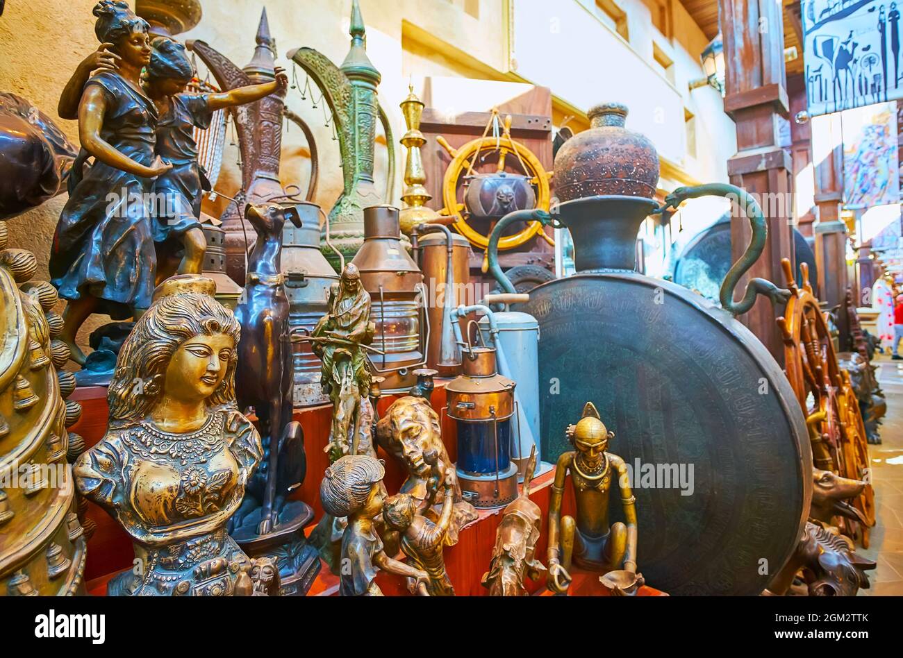 The vintage items (figurines, dallah coffee pots, lamps) on the counter of the vintage shop, Souk Madinat Jumeirah market, Dubai, UAE Stock Photo