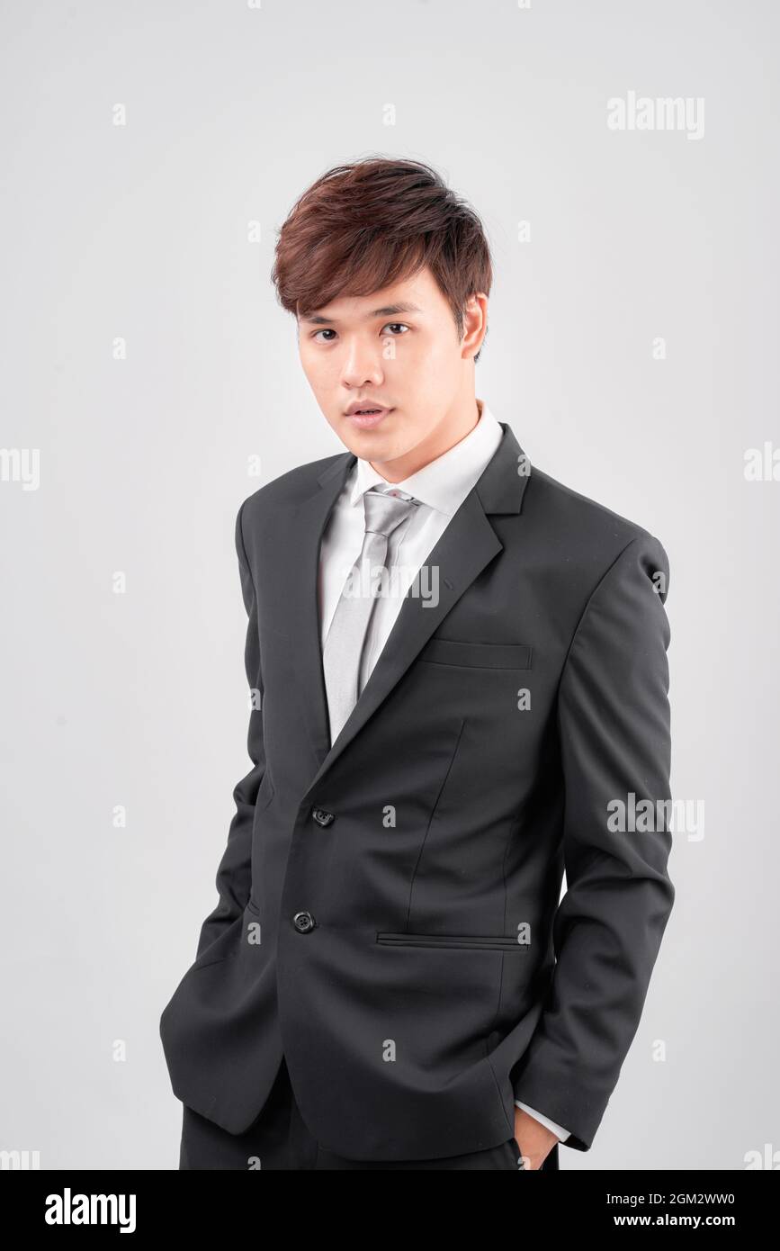 Portrait of smiling young Asian business man standing isolated on white ...