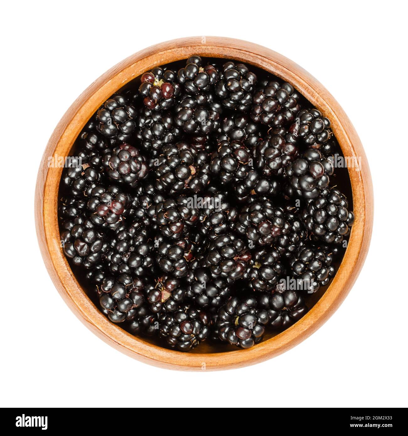 European blackberries in a wooden bowl. Fresh and ripe wild brambles, Rubus fruticosus, a sweet fruit, used for desserts and jams. Stock Photo