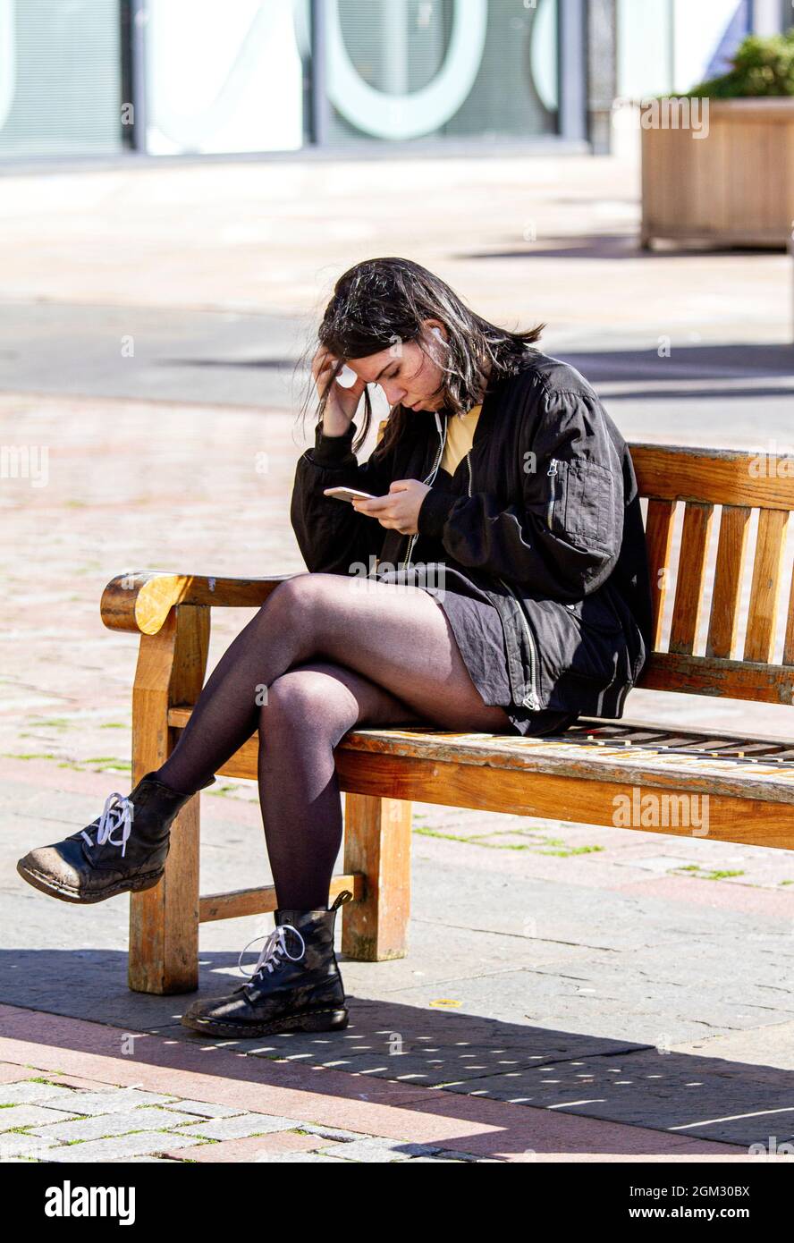 Dundee, Tayside, Scotland, UK. 16th Sep, 2021. UK weather: Warm mid September sunshine across North East Scotland with temperatures reaching 19°C. A young woman spending the day out enjoying the glorious warm sunny weather whilst texting messages on her mobile phone in Dundee city centre. Credit: Dundee Photographics/Alamy Live News Stock Photo