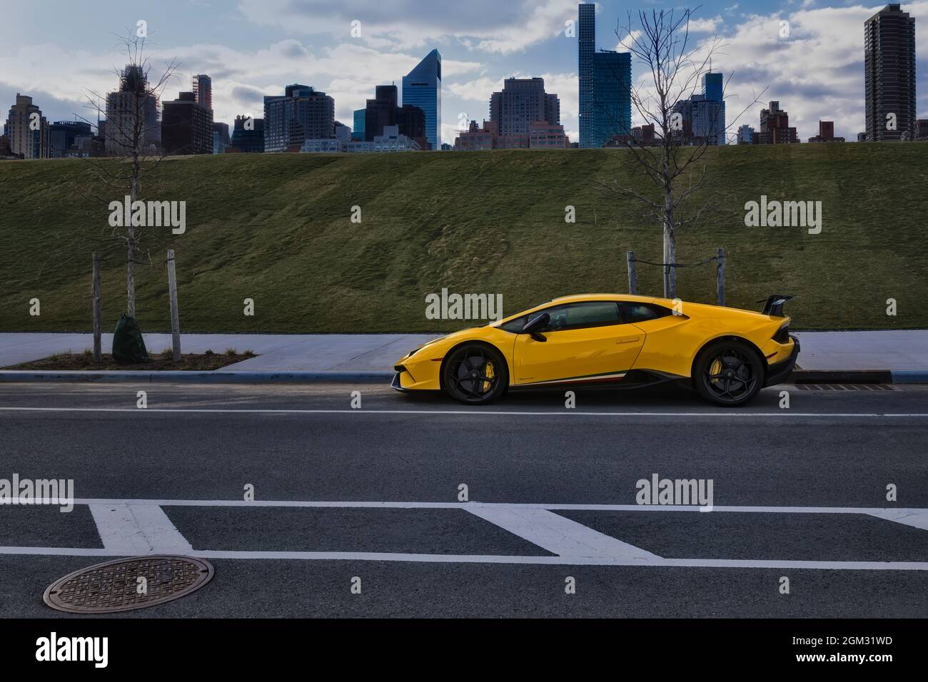Lamborghini NYC Skyline - A yellow parked Lamborghini vehicle with the upper East Side New York City Skyline.  This image is available in color as wel Stock Photo