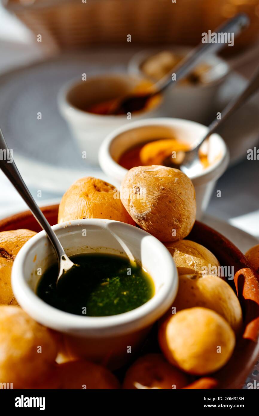 a plate with some papas arrugadas, wrinkly potatoes in Spanish, typical of the Canarian Islands, and some bowls with different mojo sauces, such as gr Stock Photo