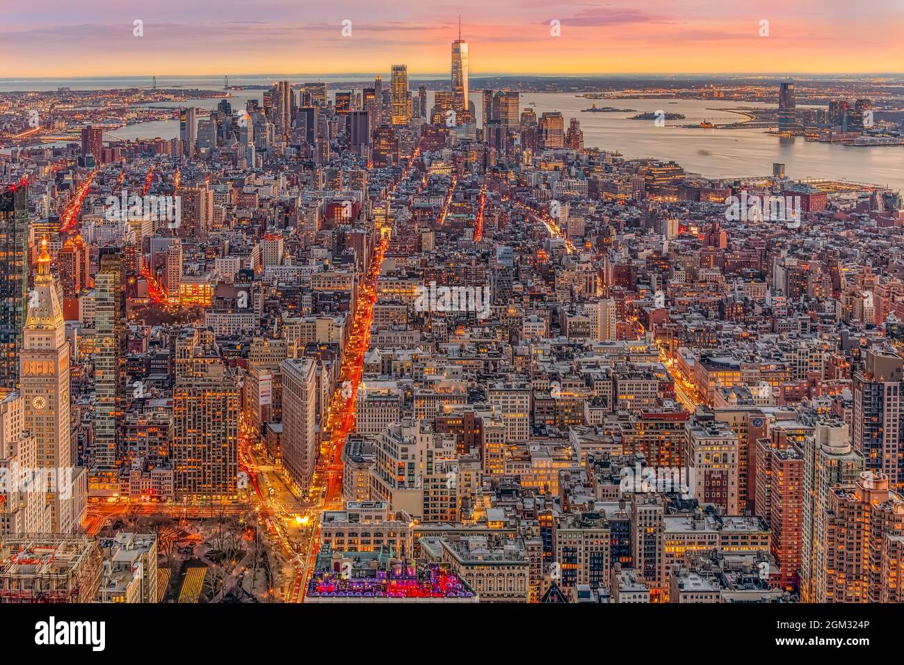 Aerial New York City Sunset - View from above to the illuminated lower Manhattan skyline with One World Trade Center WTC (Freedom Tower), Brooklyn, Ma Stock Photo