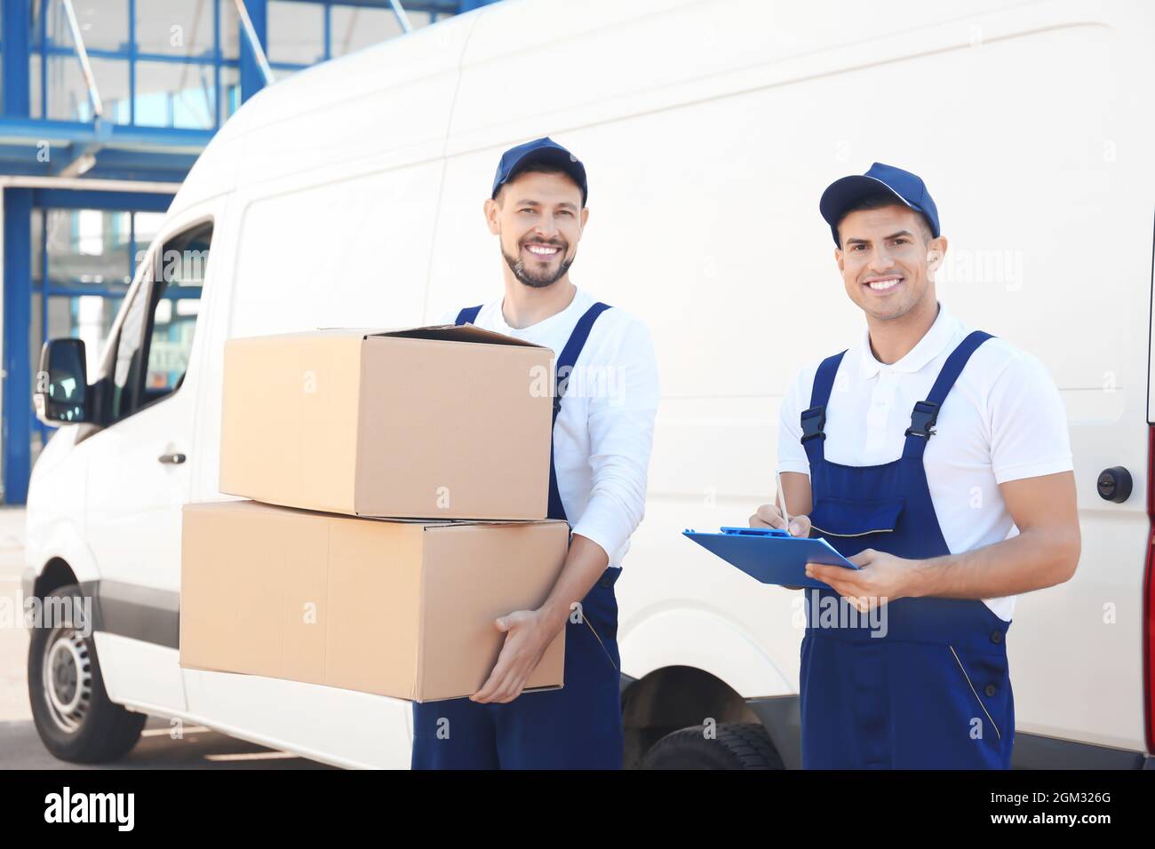 Delivery men with moving boxes near car Stock Photo Alamy