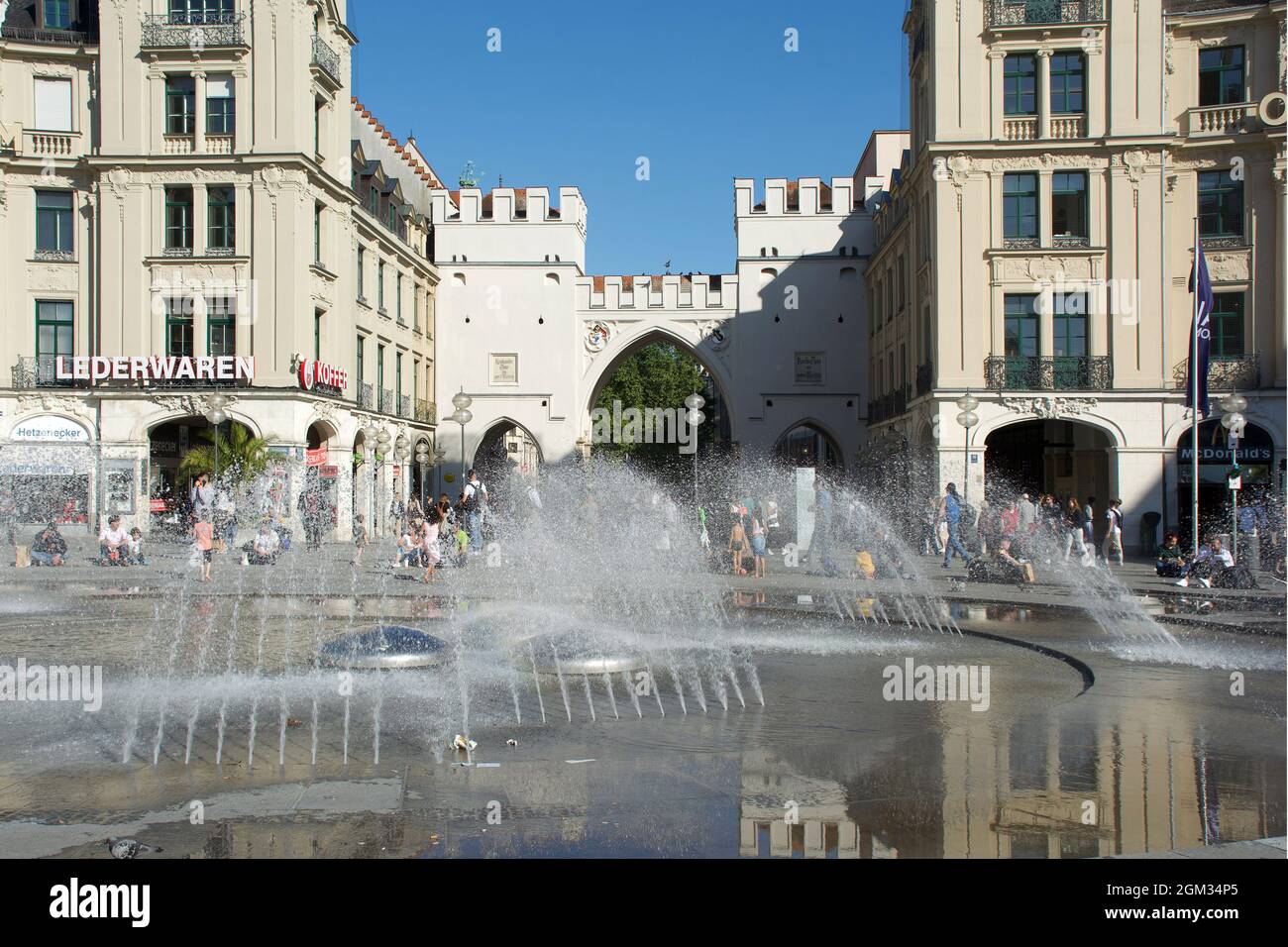 Karlstor gate from the 18th century in the old town of Munich with people in the pedestrian zone- Germany. Stock Photo