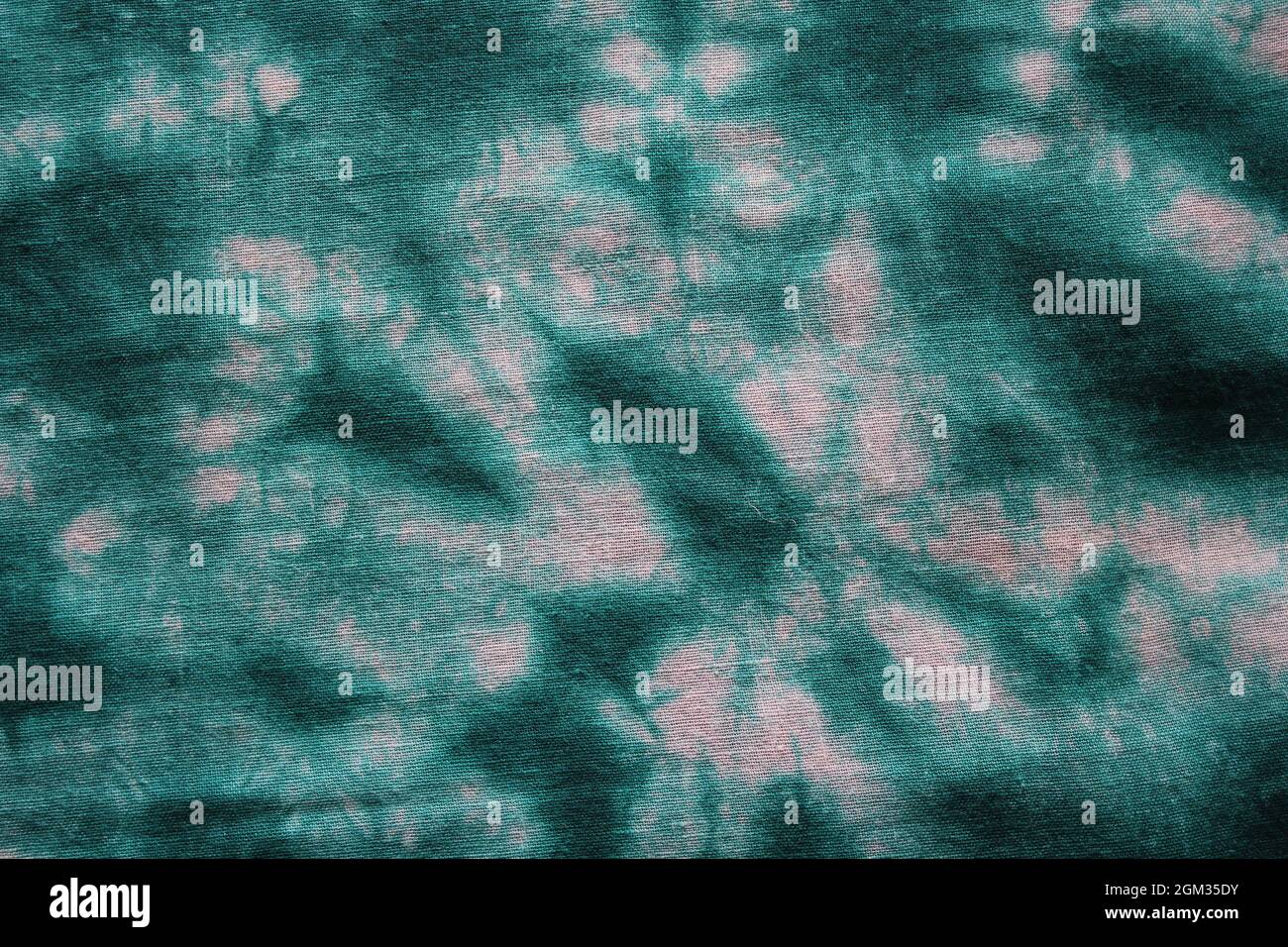Tie dye green background with half circle layers of dye pattern fading from green to white dye