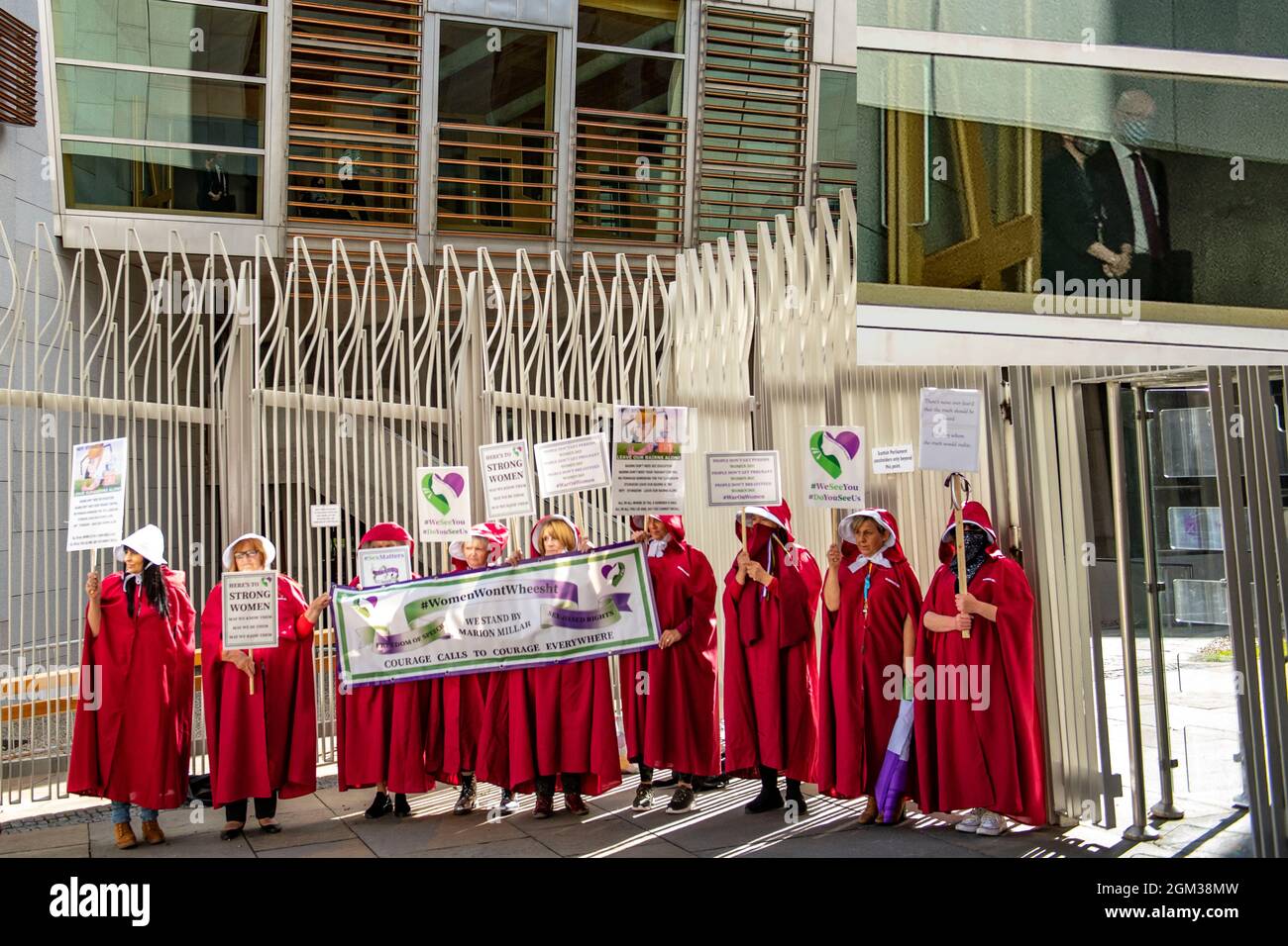 Edinburgh, Scotland, UK. 16th Sep, 2021. PICTURED: Composite image (top right pic inset) showing enlargement of (top left main pic) Nicola Sturgeon and John Swinney leaving chamber with handmaidens outside parliament. Handmaidens gather outside of Parliament where MSP's emptying from the chamber can see the handmaidens protest. Women Won't Wheesht movement march on the Scottish Parliament in protest during First Minister's Questions to make Nicola Sturgeon hear their voice on women's rights. Credit: Colin Fisher/Alamy Live News Stock Photo