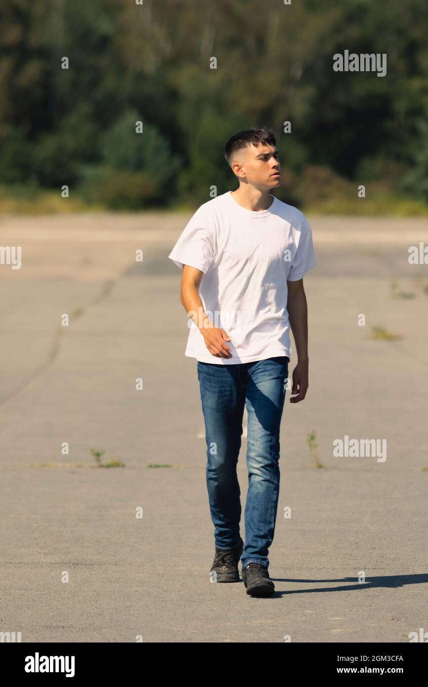 old teen boy in a white t-shirt outdoors and denim Stock Photo - Alamy