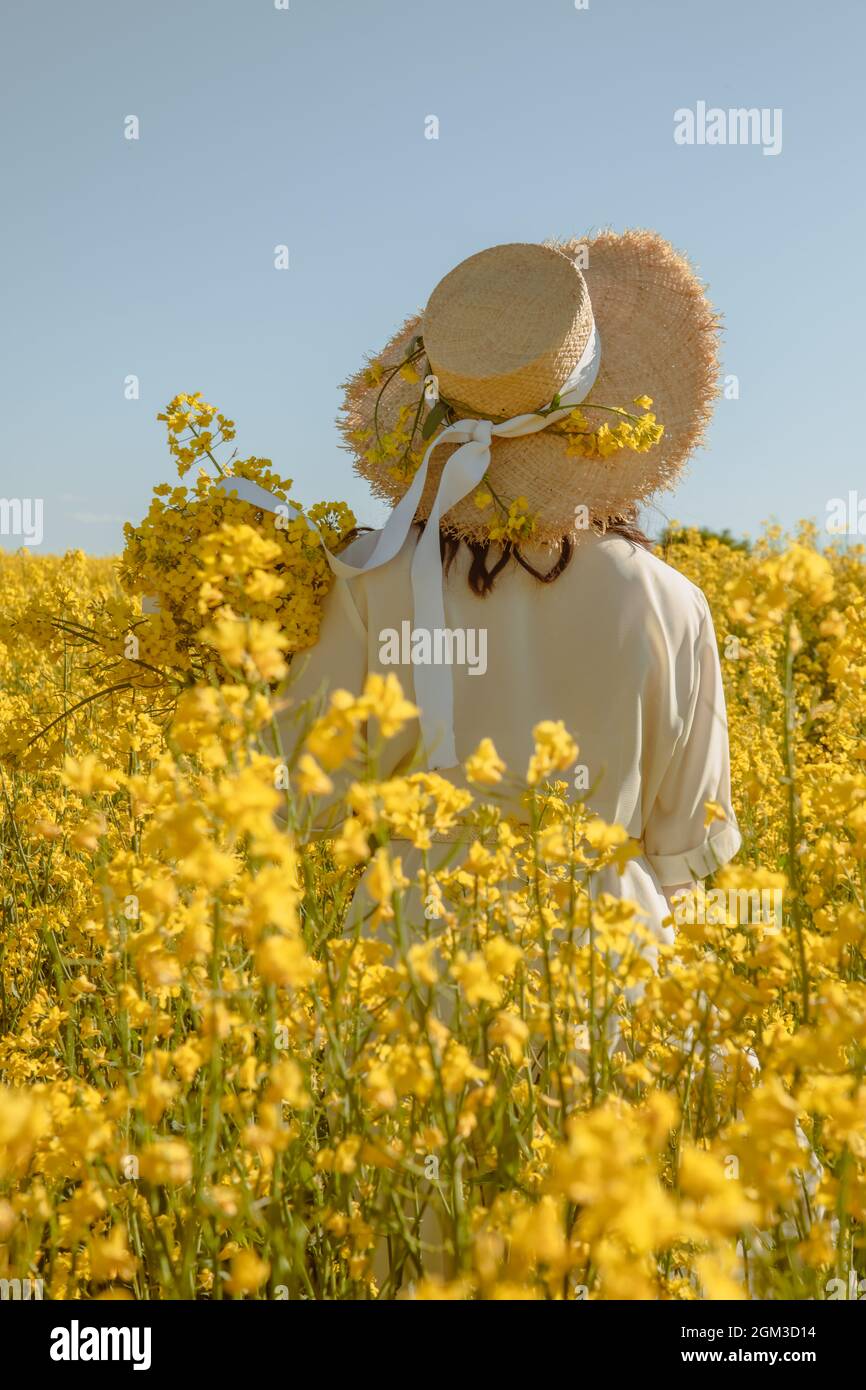 woman standing in rapeseed field rear view from behind summertime Stock ...