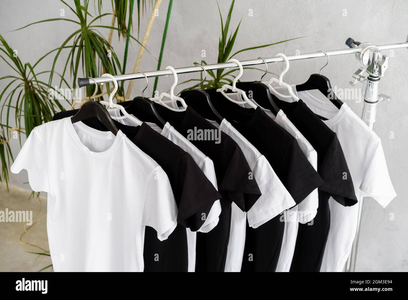 Row of black and white t-shirts hanging on rack Stock Photo