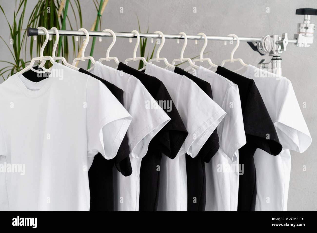 Row of black and white t-shirts hanging on rack Stock Photo - Alamy
