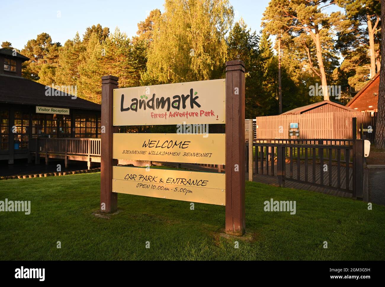 Sign for Landmark Forest Adventure Park, a theme park in the Scottish Highlands. Blurred background of visitor reception, buildings and trees. Stock Photo