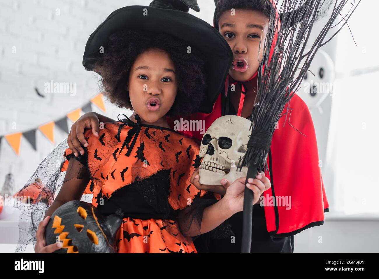 spooky african american kids in halloween costumes holding skull, carved  pumpkin and broom Stock Photo - Alamy, image size:1300x957