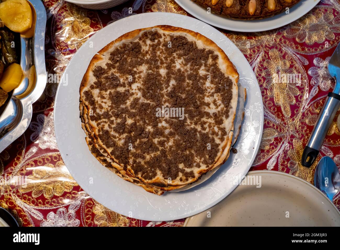 Lahmajun round, thin piece of dough topped with minced meat. Stock Photo