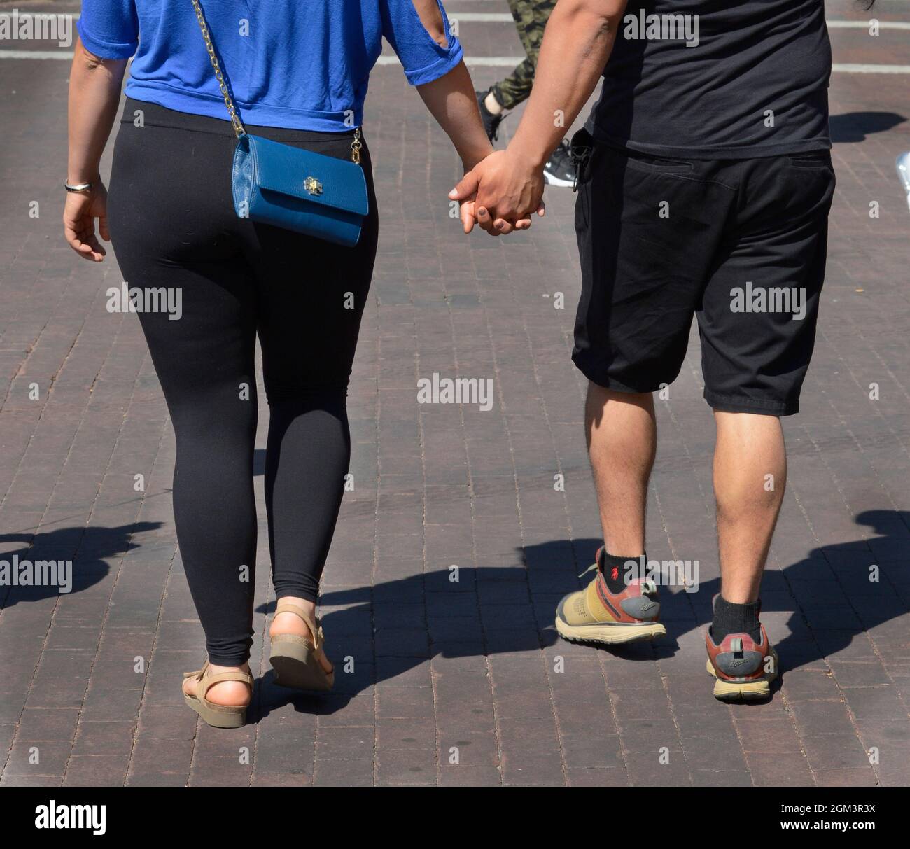 A couple holds hands as they walk in Santa Fe, New Mexico. Stock Photo