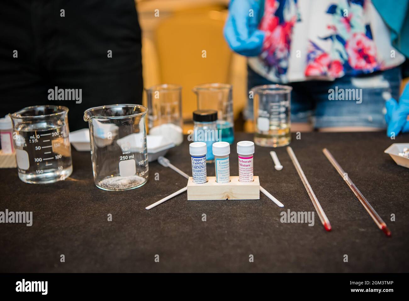 Science experiment materials including colorful liquid filled beakers and various vials and stirring mechanisms. Stock Photo