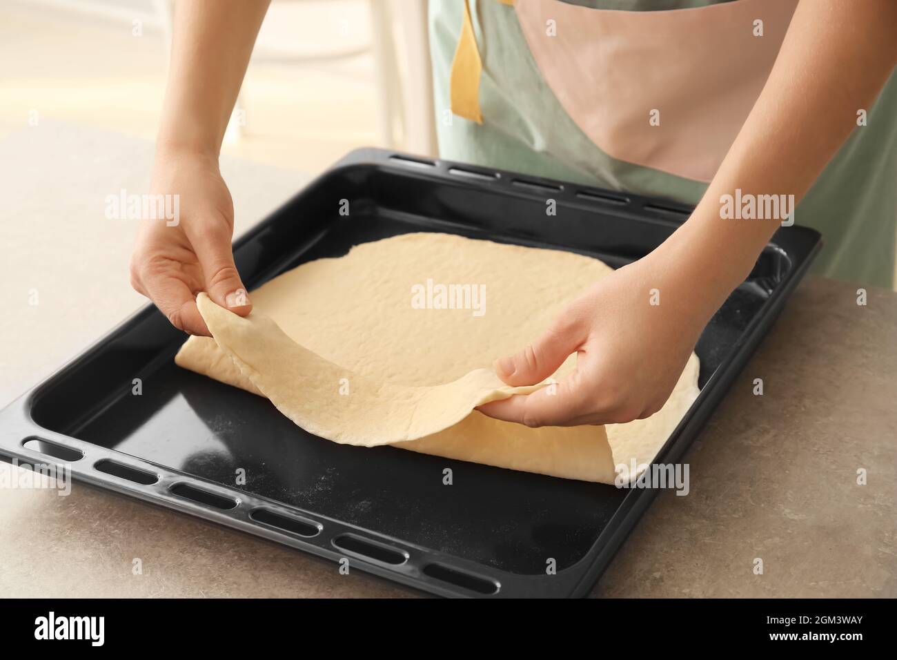 Woman putting puff pastry on baking tray Stock Photo Alamy